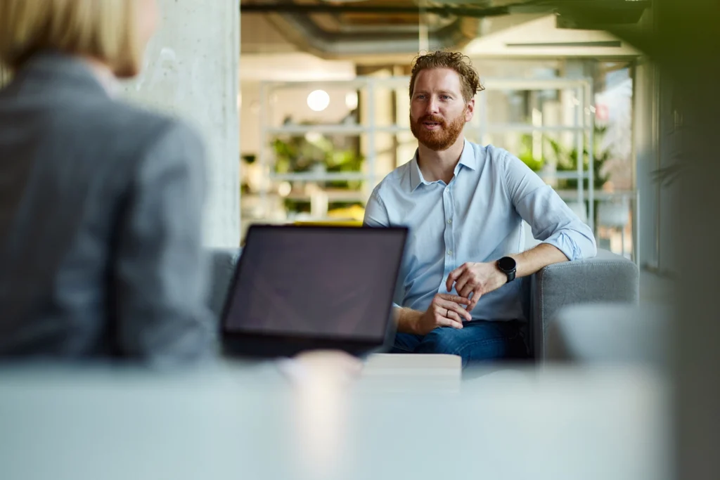 Country-Bank-banker-and-customer-sit-at-desk-discussing-real-estate-loan