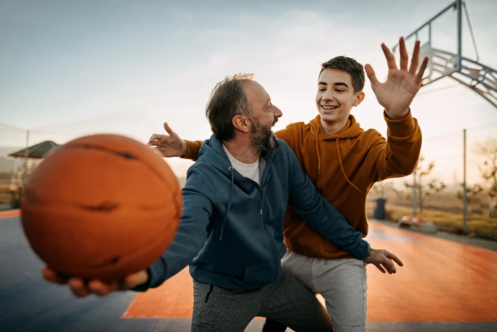 Country-Bank-father-son-playing-basketball-outside-at-park