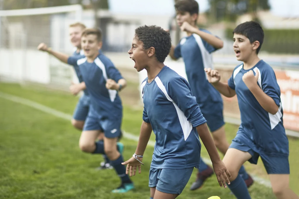 Country-Bank-five-boys-running-onto-soccer-field-in-blue-sports-uniforms