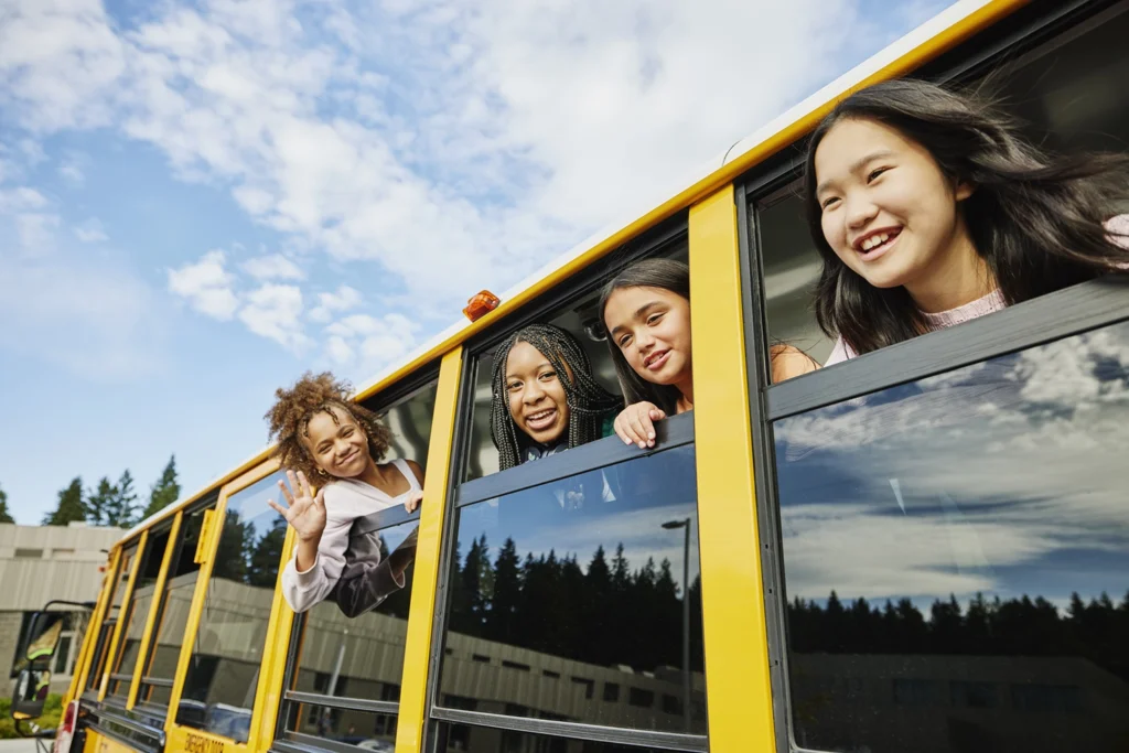 Country-Bank-four-students-poking-their-heads-out-of-school-bus-windows