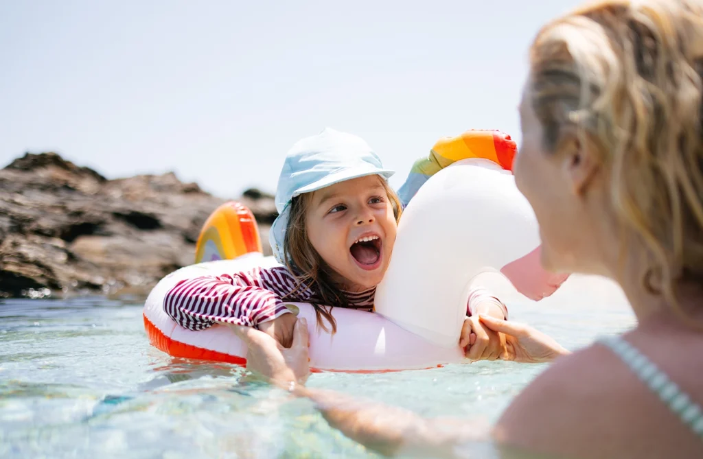 Country-Bank-girl-playing-in-floatie-in-the-water-with-her-mom-holding-her
