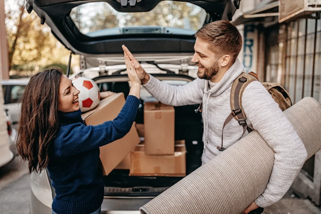 Country-Bank-man-and-woman-high-five-while-carrying-stuff-to-their-car