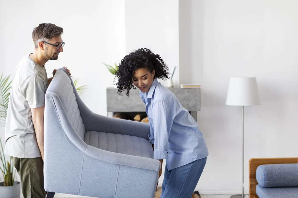 Country-Bank-man-and-woman-moving-blue-couch-in-their-home