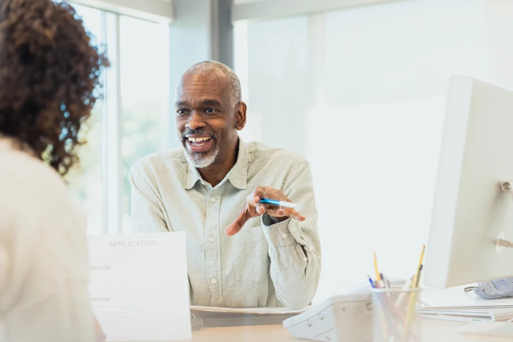 Country-Bank-man-and-woman-sitting-across-from-each-other-at-des