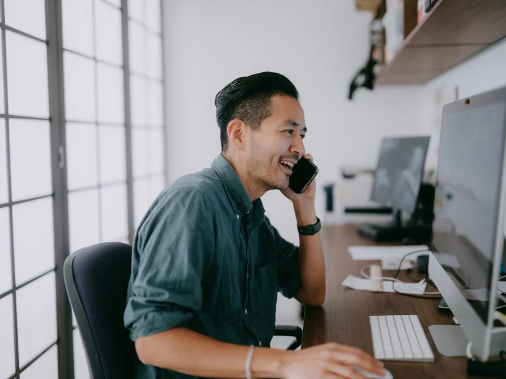 Country-Bank-man-at-computer-desk-on-phone-speaking-to-banker-about-business-wire-transfers