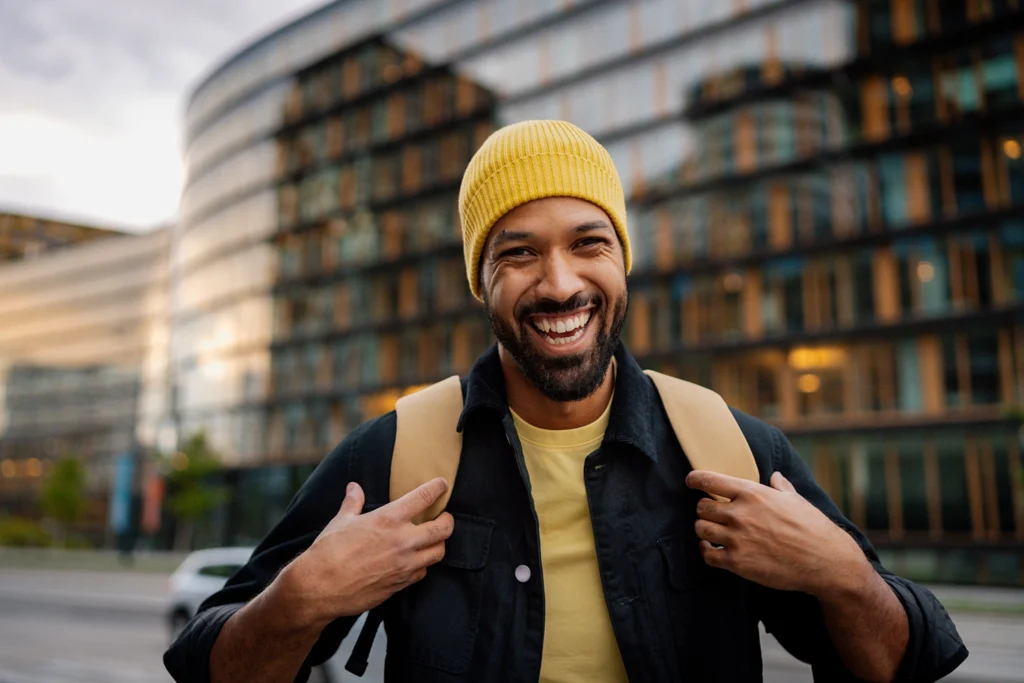 Country-Bank-man-carrying-backpack-walking-street-looking-happy