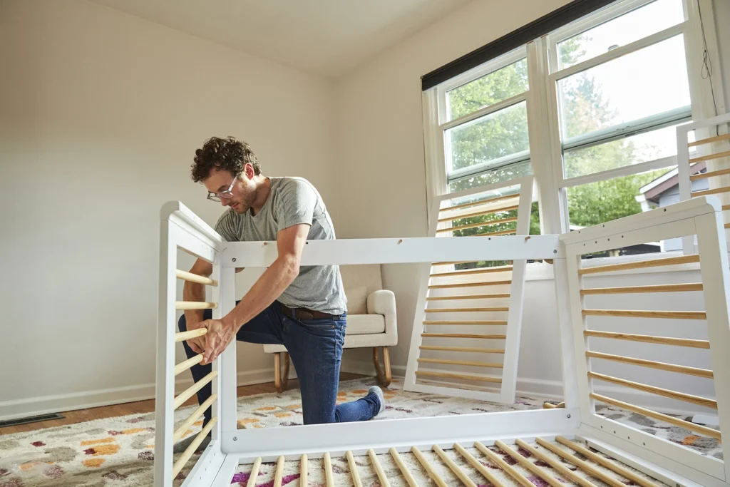 Country-Bank-man-in-room-assembling-piece-of-furniture-with-windows-open