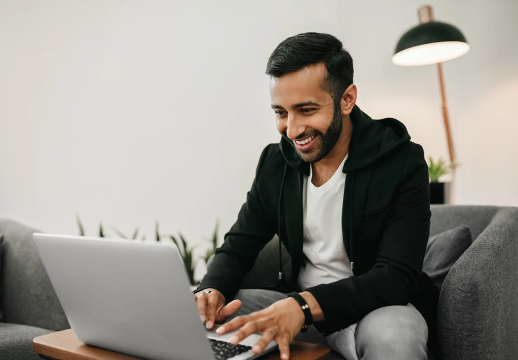 Country-Bank-man-sitting-at-couch-researching-CD-accounts-from-his-computer