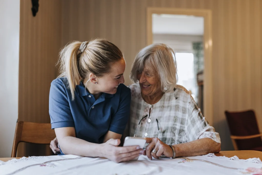 Country-Bank-mother-and-daughter-sitting-at-kitchen-table-looking-at-daughters-phone