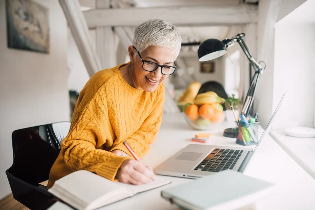 Country-Bank-professional-woman-in-glasses-and-orange-sweater-writing-on-a-notebook-1