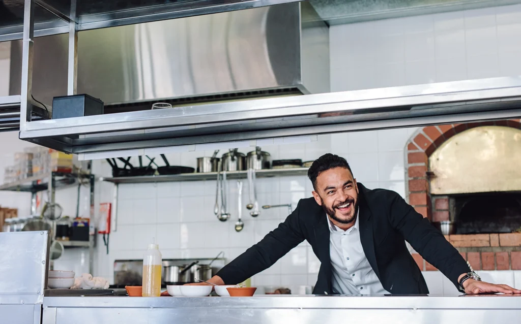 Country-Bank-restaurant-owner-behind-kitchen-counter-excited