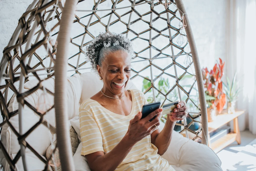 Country-Bank-senior-woman-in-bamboo-swing-chair-opening-checking-account-online