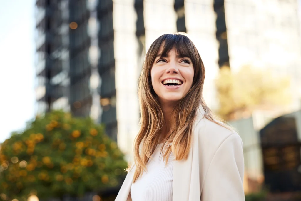 Country-Bank-smiling-woman-standing-in-front-of-highrise-looking-off-in-distance