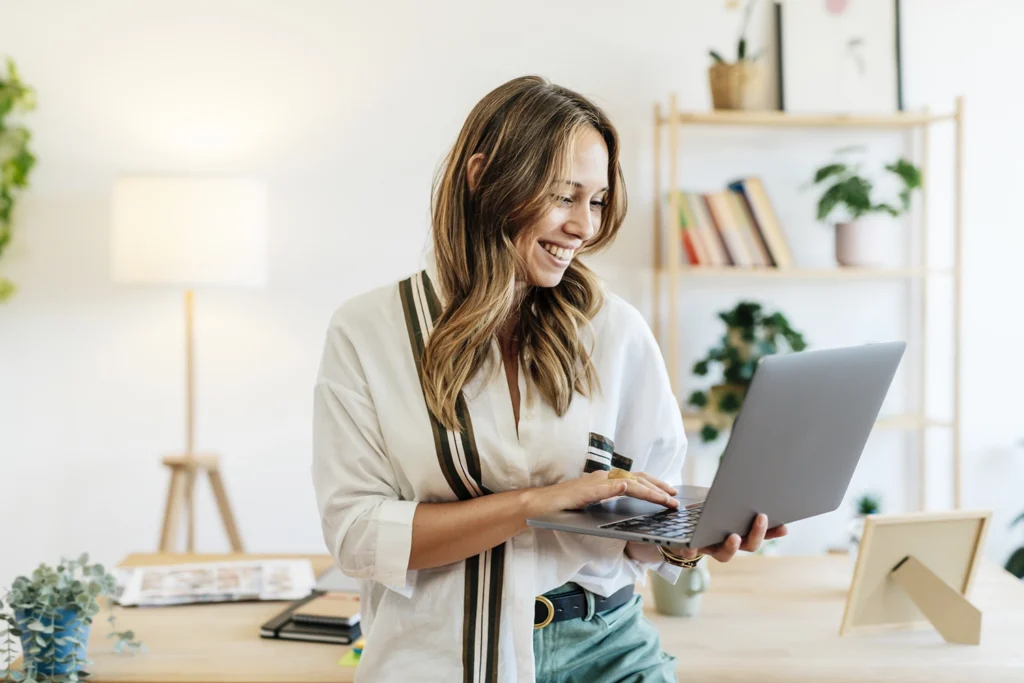 Country-Bank-smiling-woman-standing-in-room-while-typing