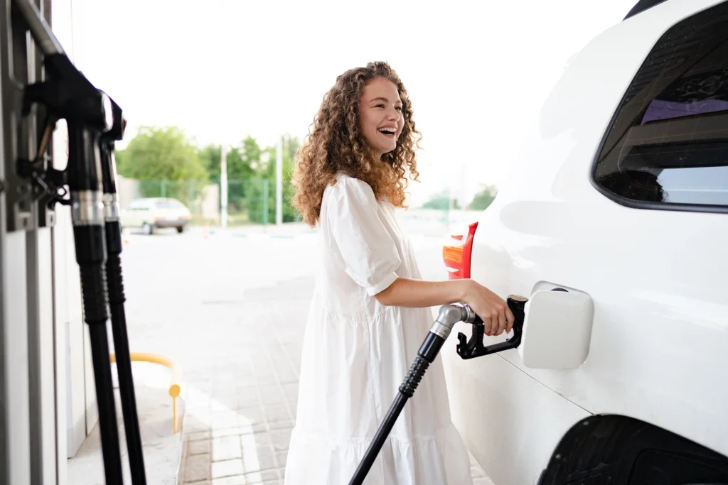 Country-Bank-woman-in-white-dress-pumping-gas-in-white-car