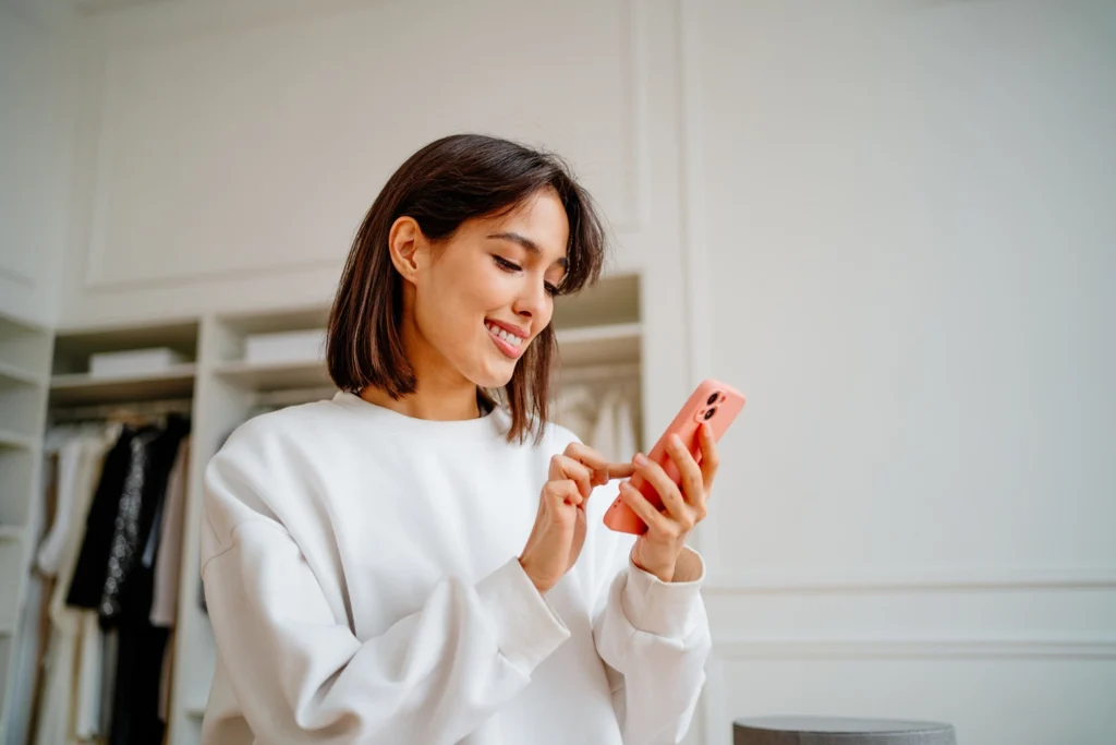 Country-Bank-woman-in-white-sweater-at-home-banking-from-her-phone