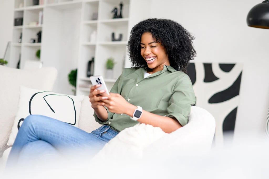 Country-Bank-woman-sitting-on-couch-applying-for-loan-from-her-phone