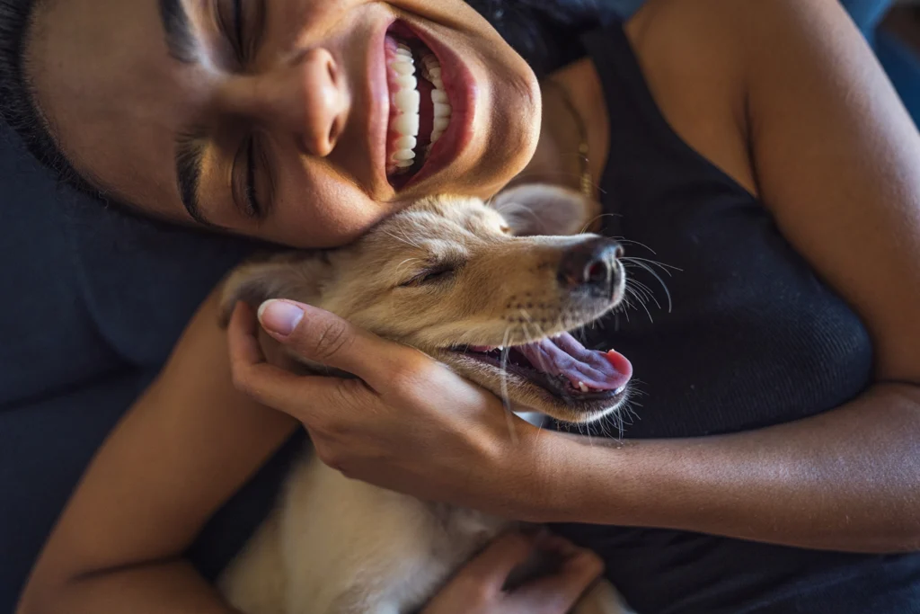 Country-Bank-young-woman-joyfully-hugs-her-dogs-head.